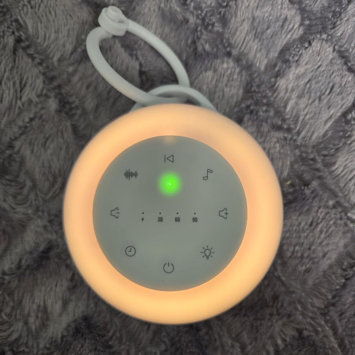 Round device with control panel on a textured gray surface