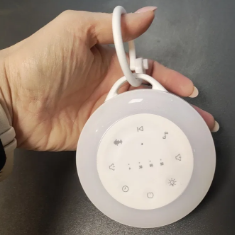 Hand holding a round white light bulb with a black background