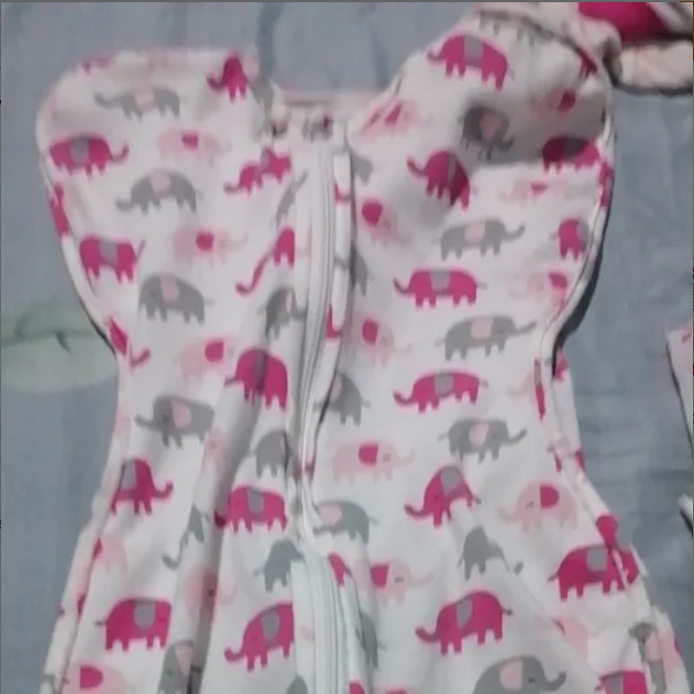 Baby swaddle with pink and gray elephant pattern on a light blue background