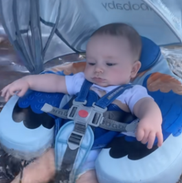 Baby in a blue baby carrier with a blurred background