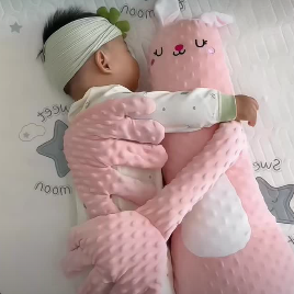 Baby lying on a pink blanket with a headband and pink bunny toy.