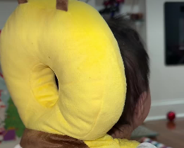 Child wearing a yellow plush toy shaped like a butterfly