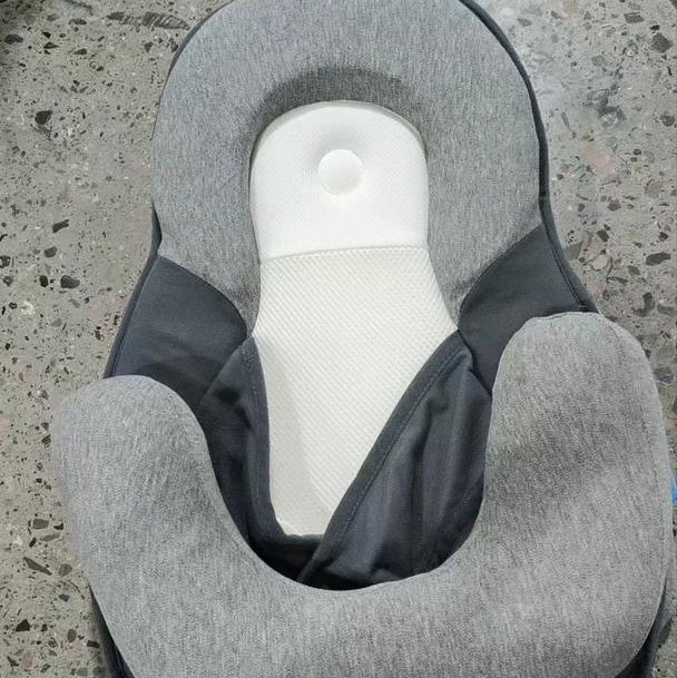 Gray neck pillow on a concrete surface